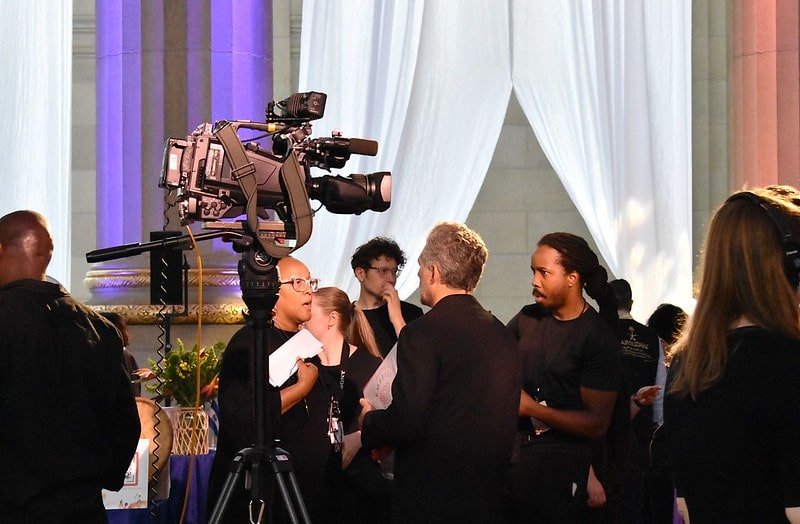 The event production team confers beneath a camera at the 2025 Embassy Chef Challenge