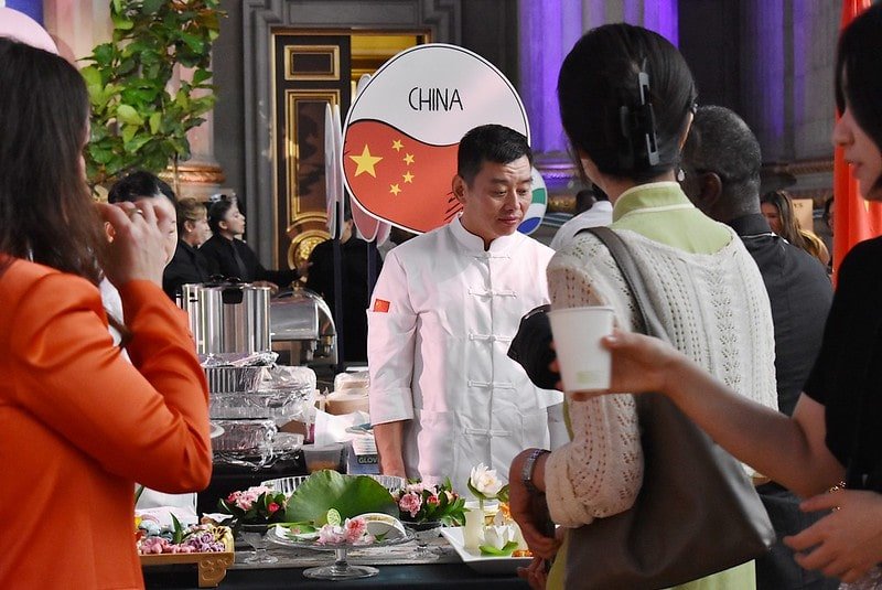A chef from the Chinese embassy presents his plates to onlookers at the 2025 Embassy Chef Challenge.