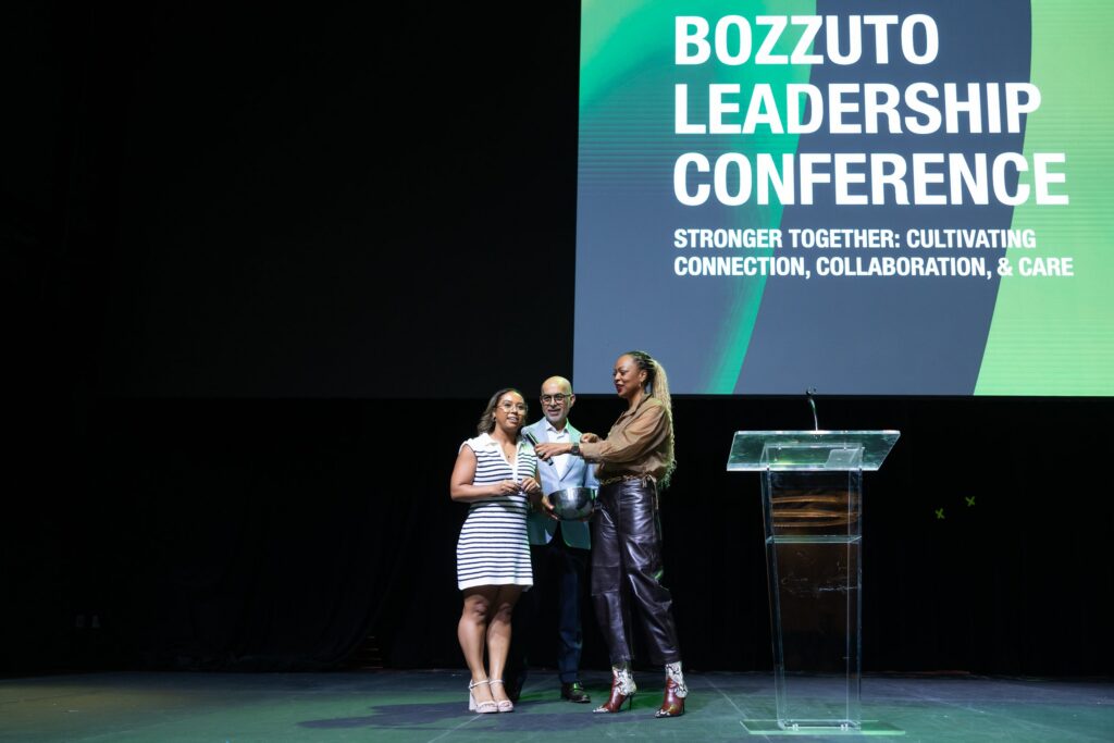 Three people onstage at the 2025 Bozzuto Leadership Conference