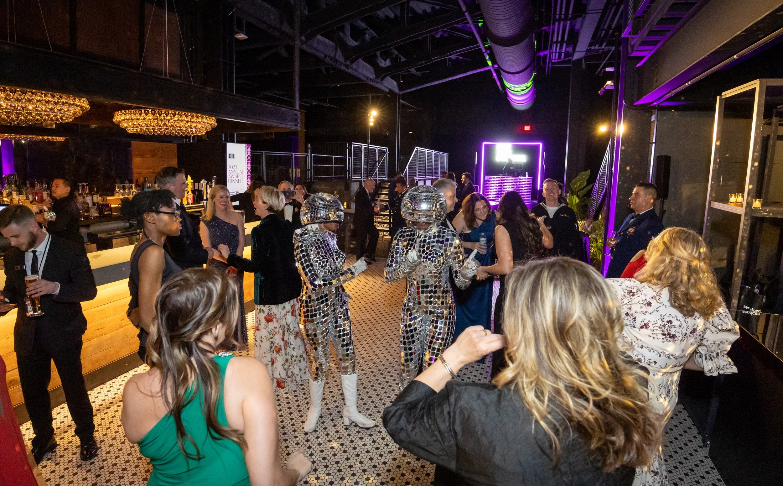 Guests and performers dressed as disco balls dance during the The USO holiday party at the Anthem produced by Stratus Firm an event production company in DC