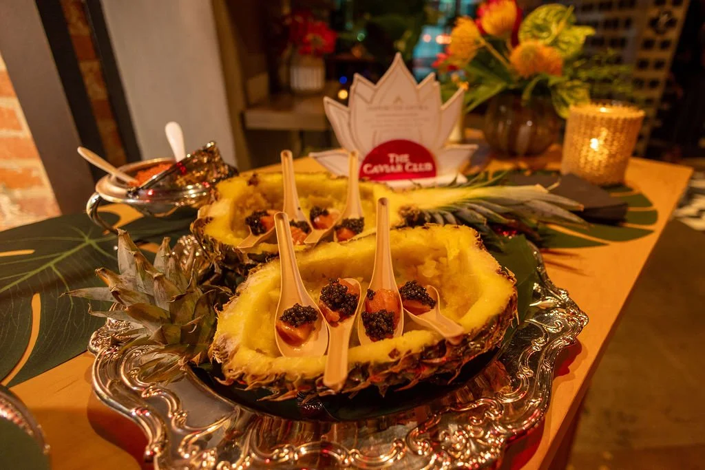 Hollowed pineapples hold spoonfuls of caviar