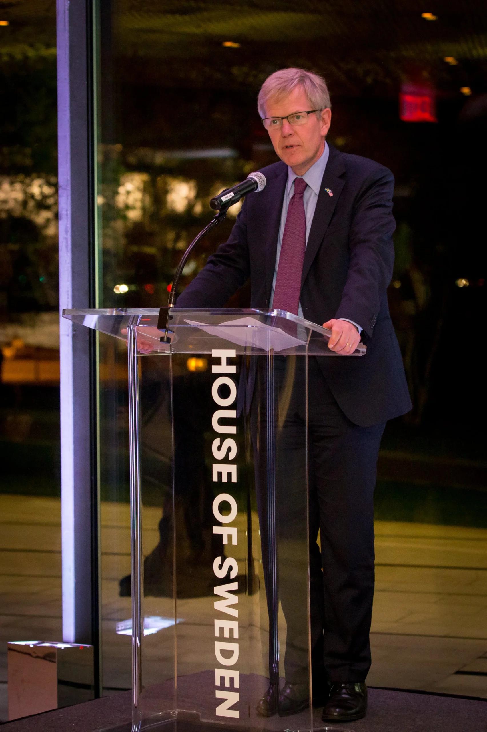 Man standing at a lecturn at the House of Sweden during an event produced by Stratus Firm, an event agency based in Washington D.C.