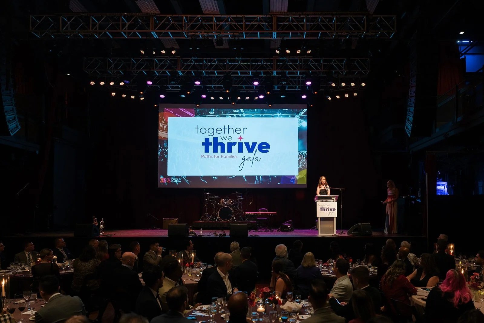 A woman speaks at a podium at the Paths for Families Gala