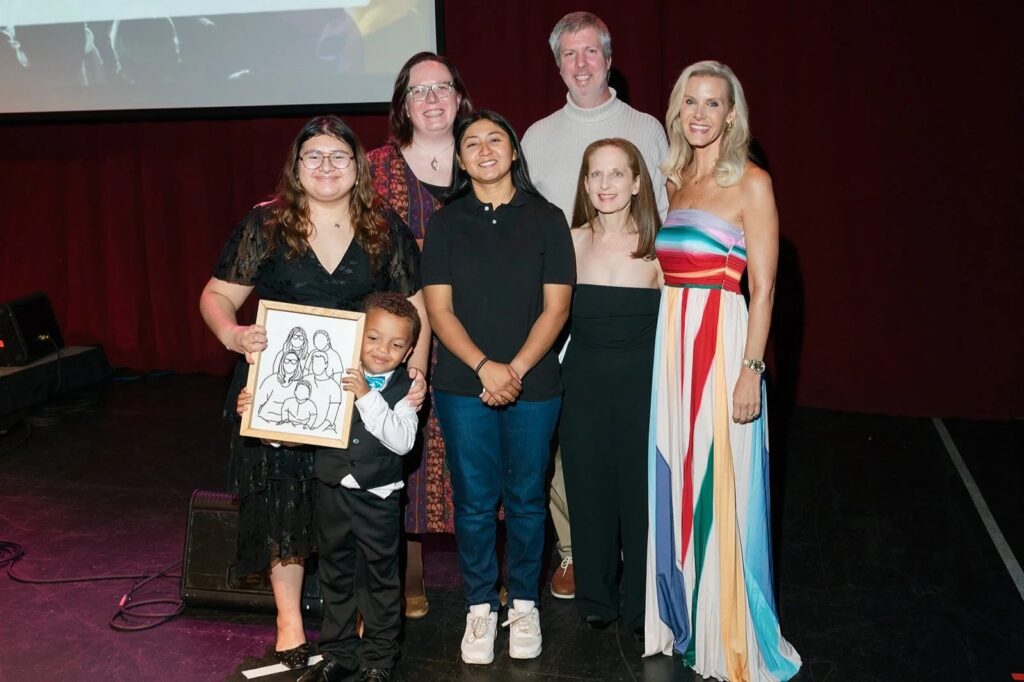 A group of people stand together onstage at the Paths for Families Gala.