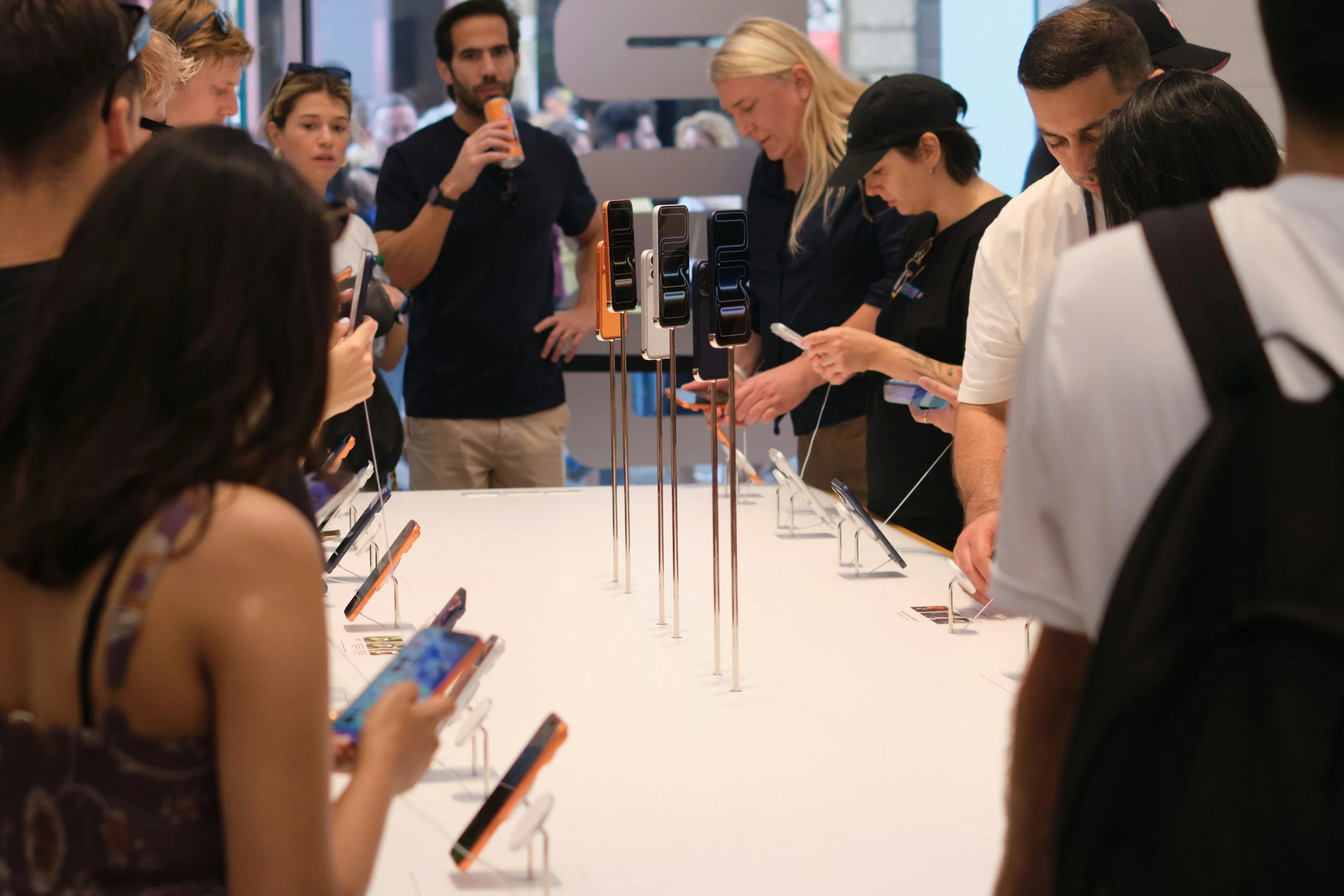 People pick up and try out phones around a table at a product launch.