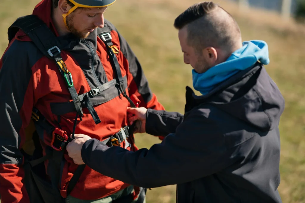 Two men checking safety gear at an event.