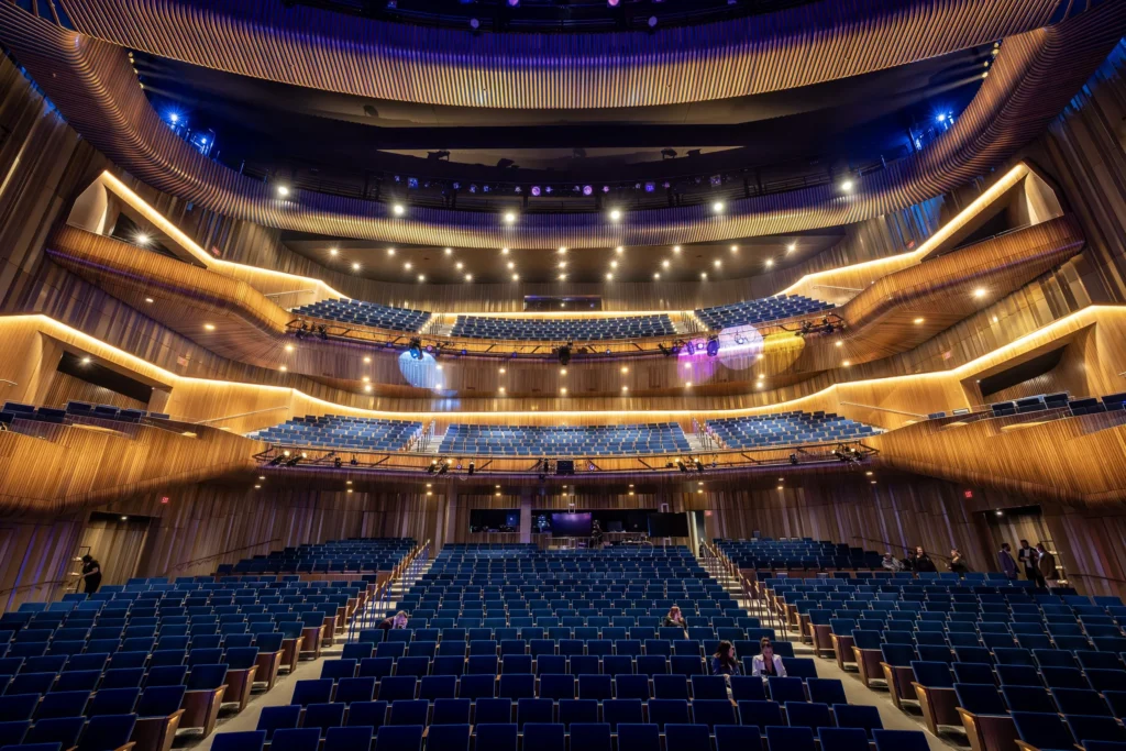 A grand auditorium, empty except for the event setup team.