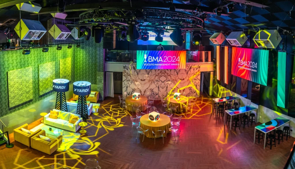 Tables and couches set up under colorful lighting at the 2024 Bozzuto Management Awards