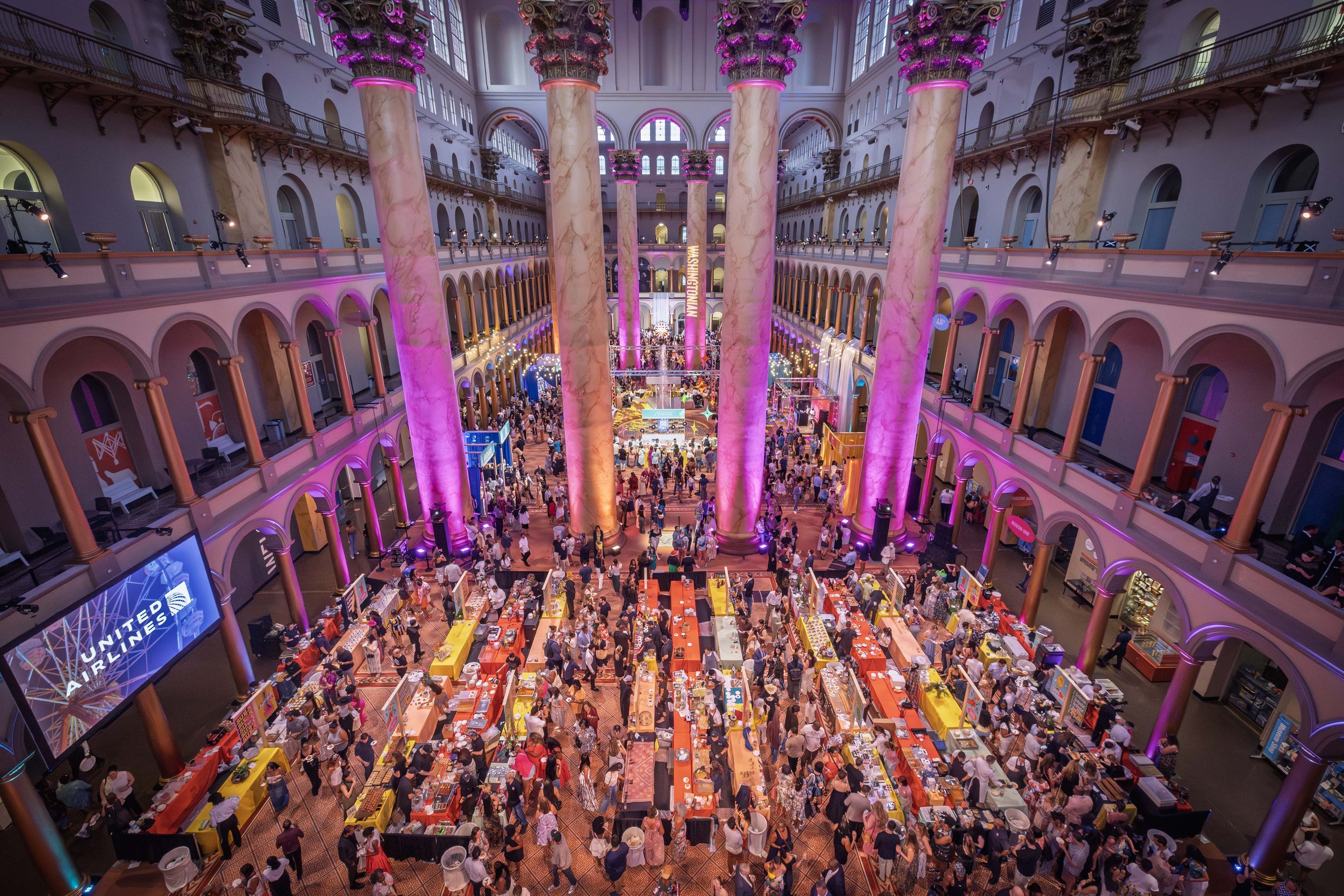 Event tables and warm pink lighting fill the space at the 2025 Best of Washington event.