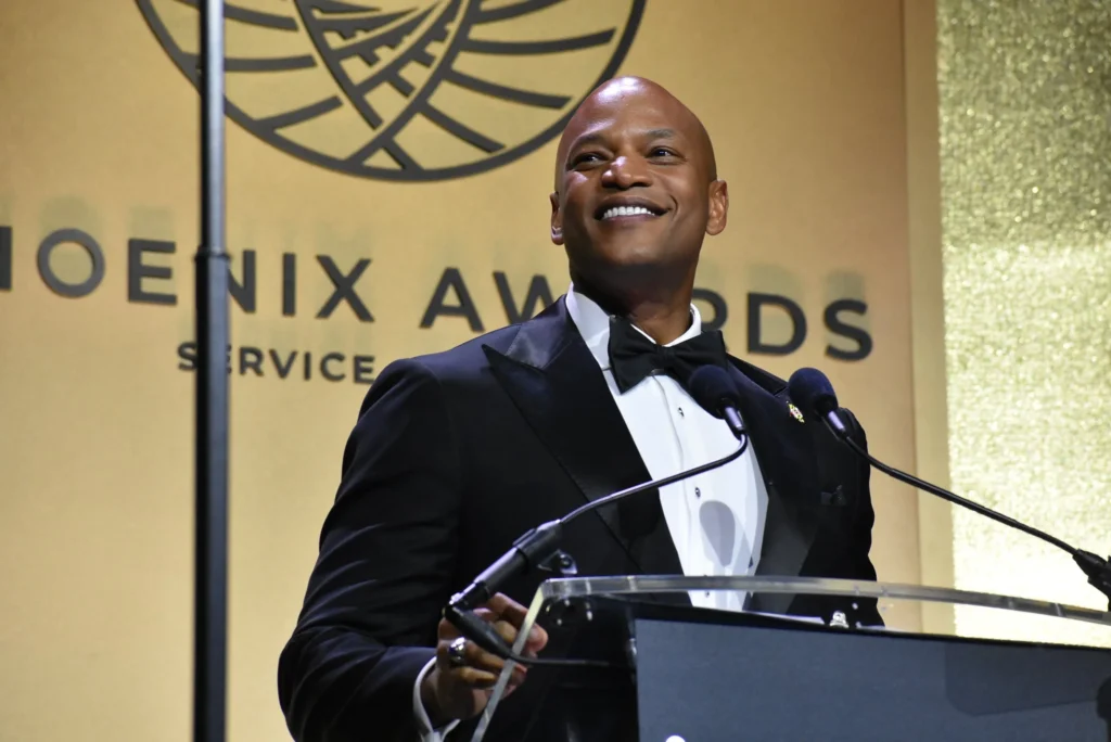 A man smiles as he speaks at the podium for the 2025 Congressional Black Caucus Foundation's Phoenix Awards Dinner