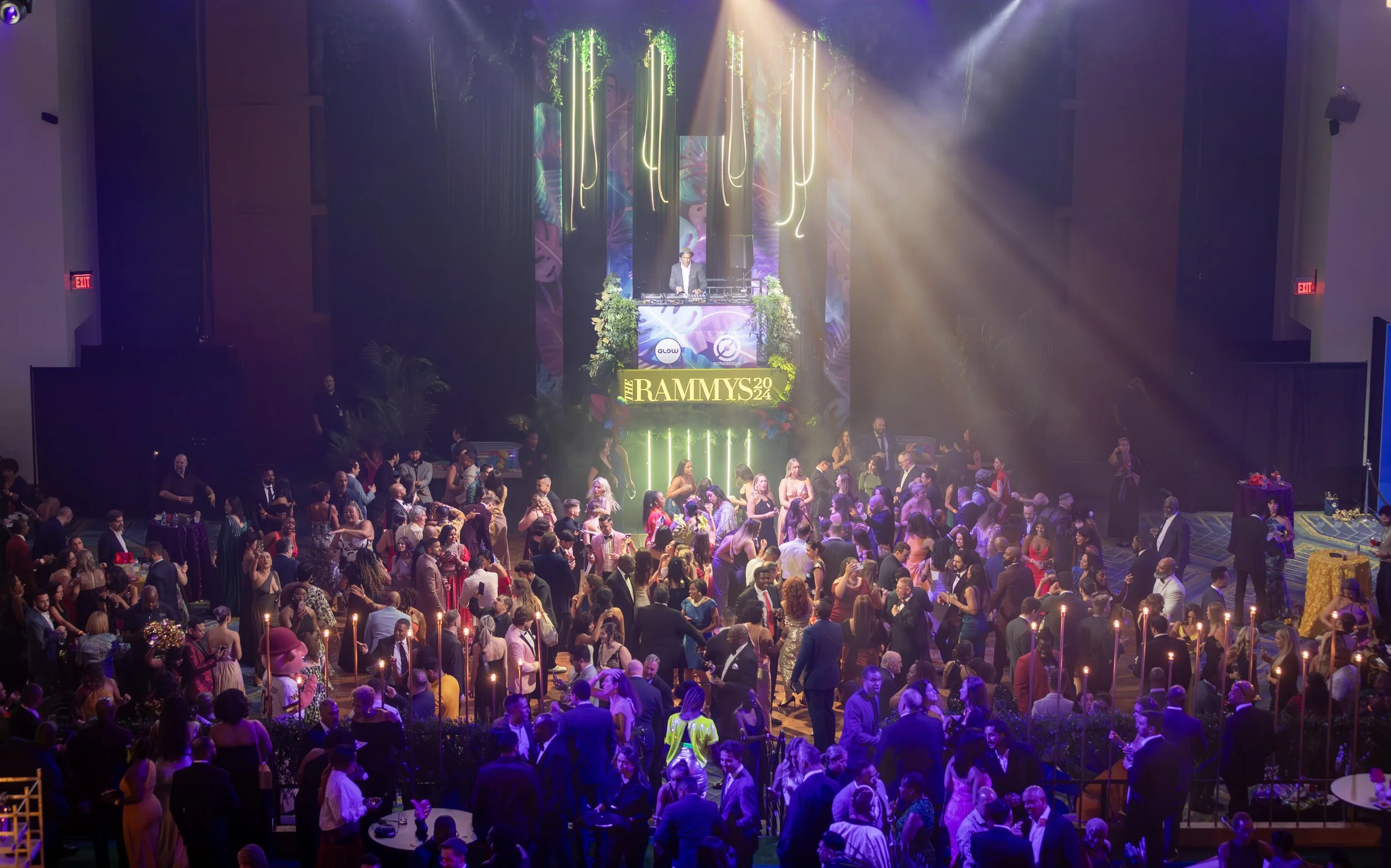 Lights shine down on event attendees dancing, eating, and mingling at the 2024 RAMMY Awards.
