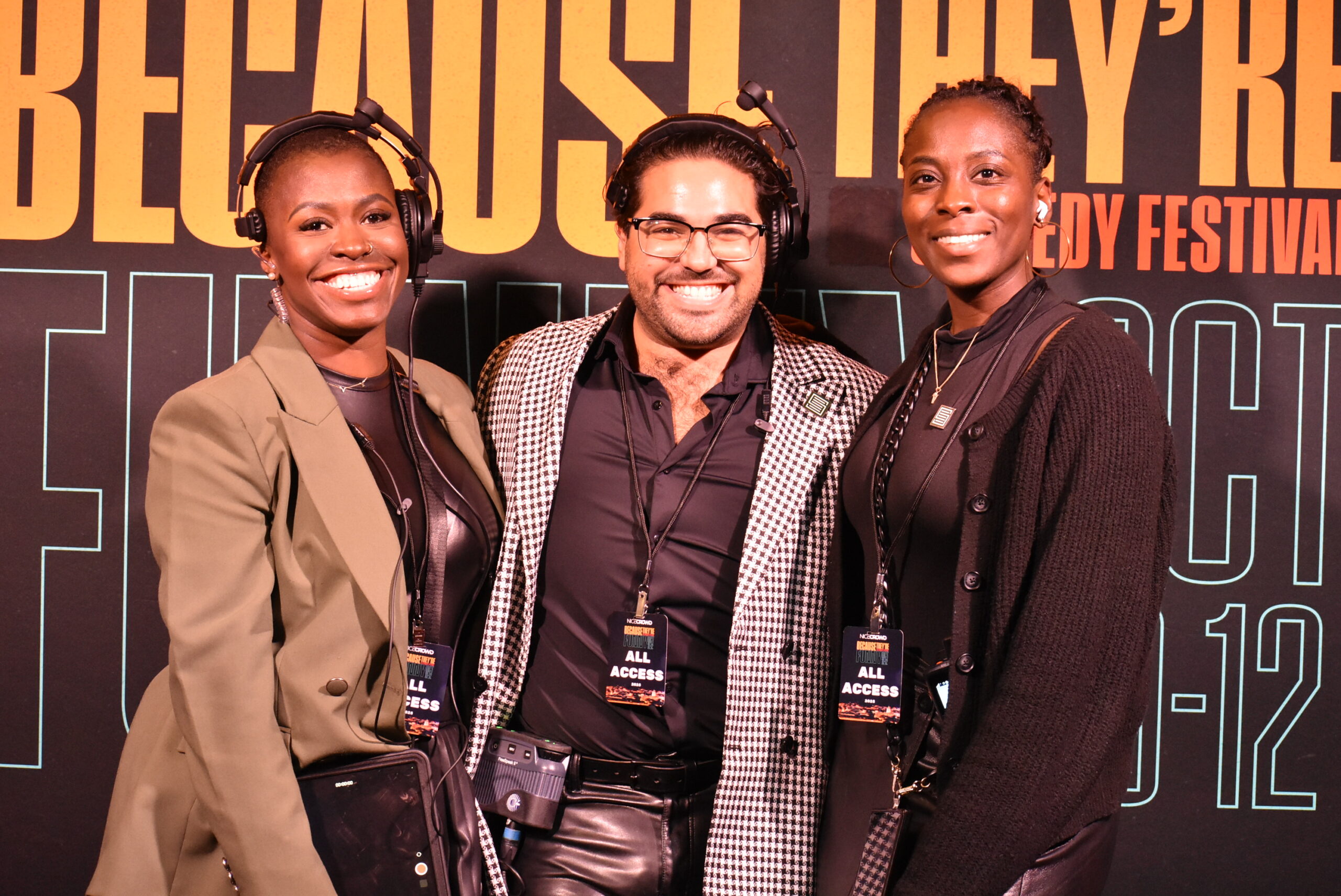 Three people smile for the camera at the "Because They're Funny" Comedy Festival.