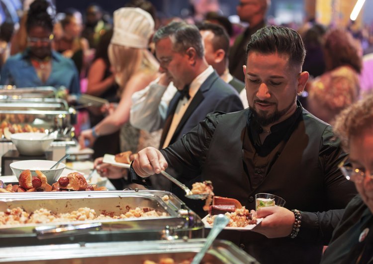 A man serves himself from a food table at the 2025 RAMMYS Awards.