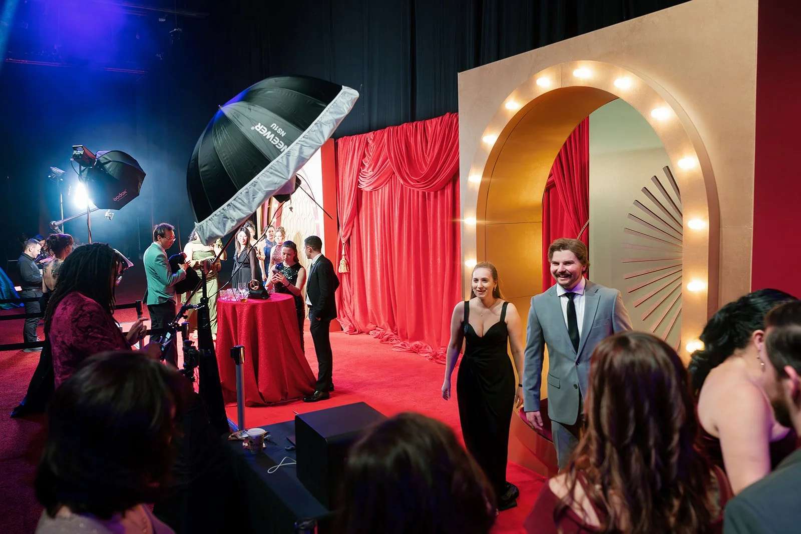 Guests take photos at a photo station and a branded backdrop.