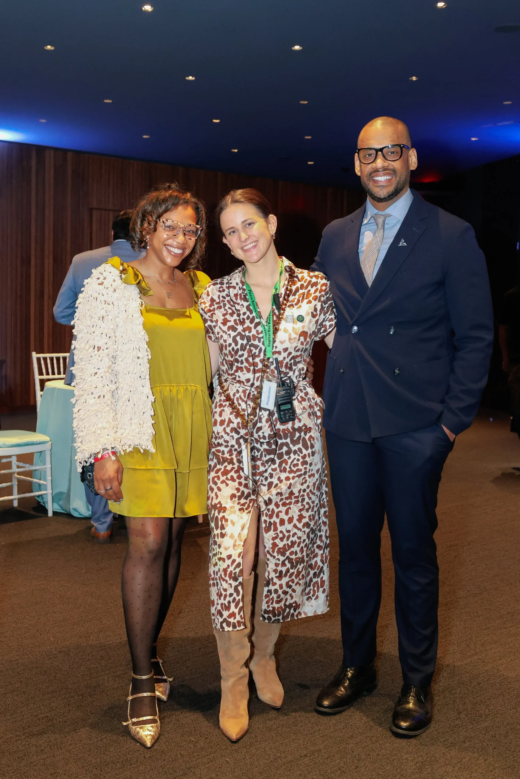 Three people pose together at an event.